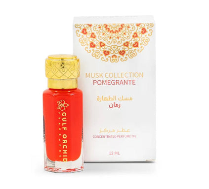 A bottle of Cote Organe Musk Collection Pomegrante concentrated perfume oil with a gold cap, standing next to its white packaging box with gold ornamental detailing.