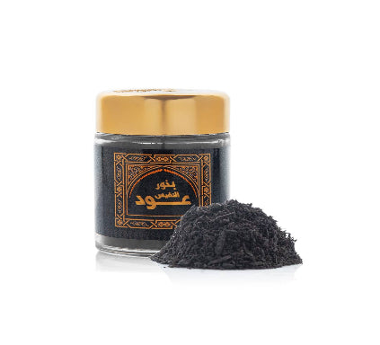 Jar of black powder with a gold lid on a white background