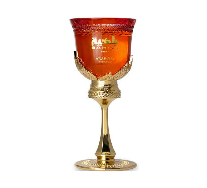Decorative glass with gold base and red top on a white background