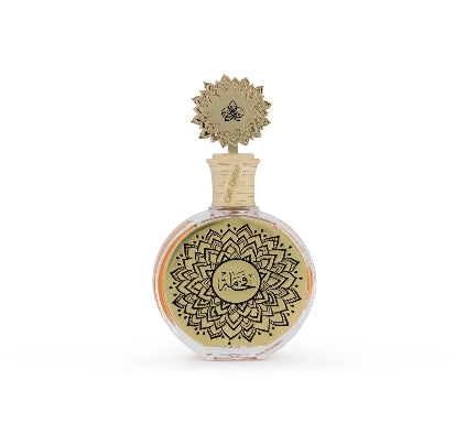A round glass perfume bottle with a gold-toned lid and a gold label featuring black mandala-style patterns and Arabic calligraphy, set against a plain white background.