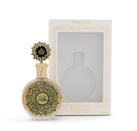 A round glass perfume bottle with a gold-toned lid and a gold label featuring black mandala-style patterns and Arabic calligraphy, set against a plain white background.