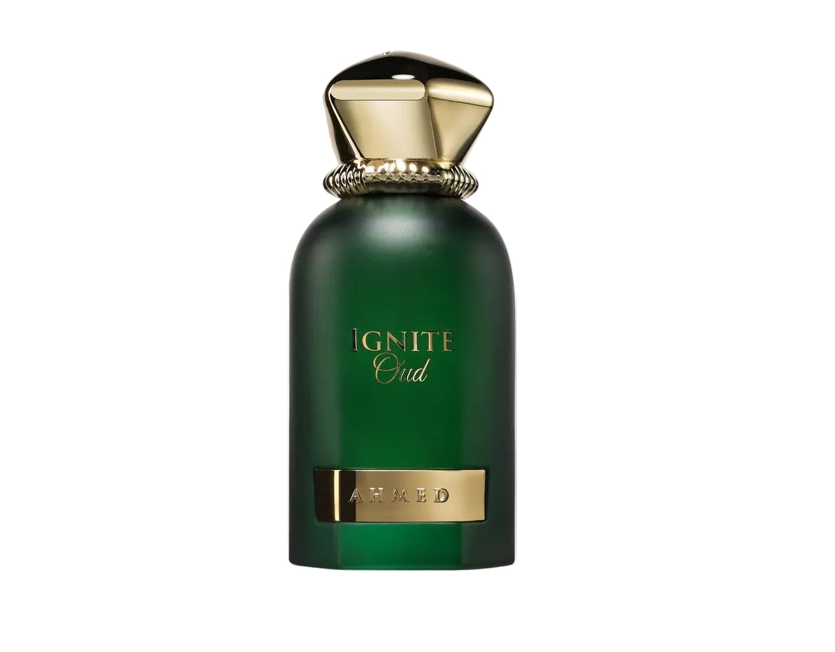 A green perfume bottle with a metallic gold cap and gold lettering that reads 'IGNITE Oud' and 'AROMAT', shown against a black background with a white border.